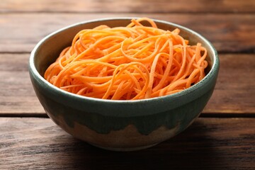 Vegetable noodles in bowl on wooden table, closeup