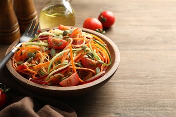 Tasty vegetable noodles served on wooden table, closeup