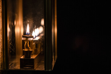 Flickering flames of burning Hanukkah candles inside a glass housing during the celebration of the Festival of Lights in Jerusalem, Israel.