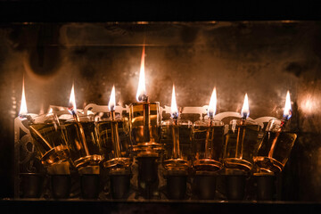 Flickering flames of burning Hanukkah candles inside a glass housing during the celebration of the Festival of Lights in Jerusalem, Israel.