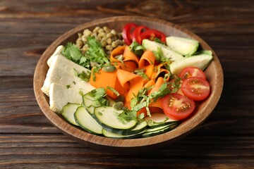 Healthy vegetarian food. Delicious Buddha bowl with lentils, tofu and vegetables on wooden table, closeup