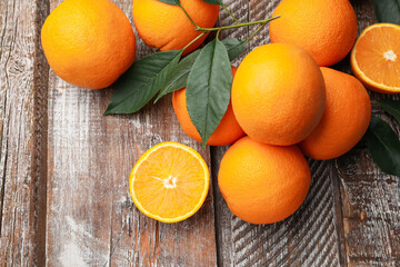 Fresh oranges and leaves on wooden table, flat lay