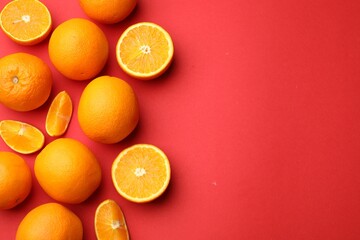 Fresh ripe oranges on red background, flat lay. Space for text