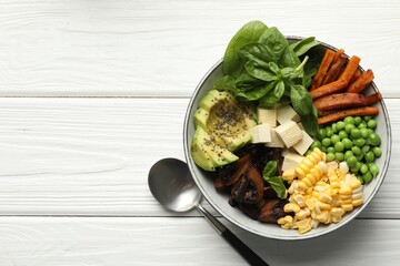 Healthy vegetarian food. Delicious Buddha bowl with tofu, mushrooms, avocado and vegetables on white wooden table, top view. Space for text