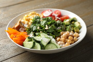 Different healthy vegetarian food on wooden table, closeup
