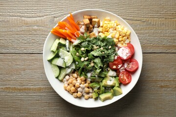 Different healthy vegetarian food on wooden table, top view