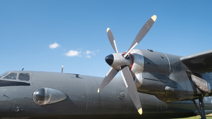 A vintage Soviet aircraft stands proudly under a clear blue sky, highlighting its unique propeller design and signifying the rich aviation history of Russia.