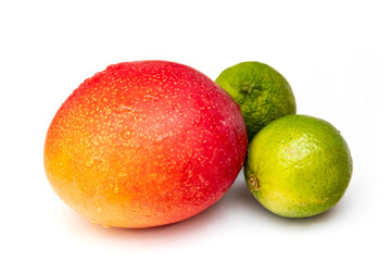 Kent Mango with a couple of limes isolated ona white studio background.