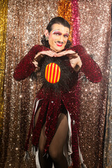 Smiling Drag Queen Poses Glamorously in Front of Sparkling Sequin Curtains at a Vibrant LGBTQ Event