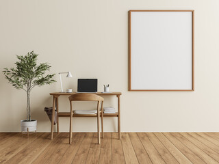 Warm-toned home office with laptop, natural wood desk, and blank poster frame on cream wall