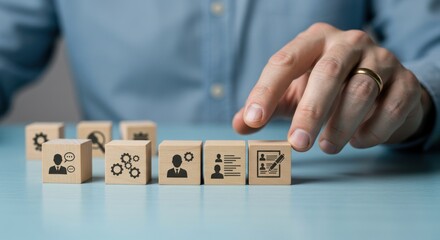 Cubes showing icons representing business processes selected by hand on a blue surface