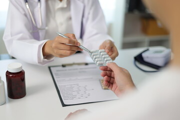 Female doctor explaining medicine dosage to patient during appointment in medical clinic. Health...
