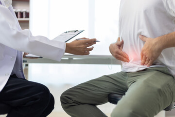 Man with abdominal pain, bloating, diarrhea goes to the doctor at medical clinic. Female doctor is...