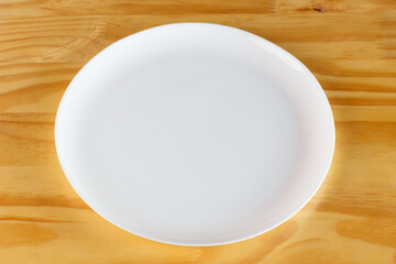 White plate on a wooden table.