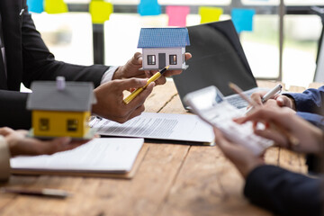 Real estate agents are presenting contract agreements and discussing housing projects with clients.