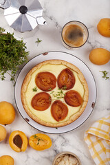 Cheesecake pie tart with apricots and thyme. Delicious homemade summer dessert with fruits. Top view.