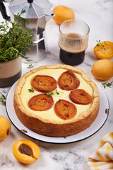 Cheesecake pie tart with apricots and thyme. Delicious homemade summer dessert with fruits. 