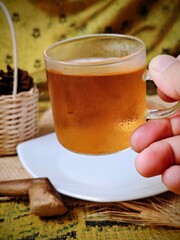Steaming Tea in Glass Cup Held by Hand Rustic Still Life.