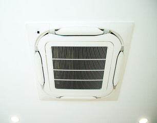Ceiling-mounted air conditioner with integrated light and speaker, showcasing modern HVAC design..