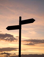 Silhouette of a Directional Signpost at Sunset.