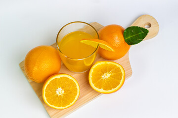 Fresh Orange Juice and Whole Sliced Oranges on a Board