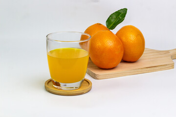 Fresh Orange Juice and Whole Oranges on White