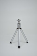 A compact mini tripod, perfect for stable photography or videography. Silver metallic finish on a...