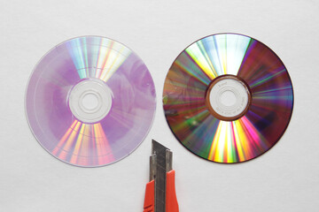 接合部分で二つに割ったDVDディスクとカッターナイフの刃先