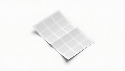 A sheet of white stickers with rounded corners on a white background folded in the middle once