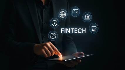 Businessman with tablet in dark room, interacting with glowing fintech icons and fintech text, symbolizing ai finance, data security, fintech startup