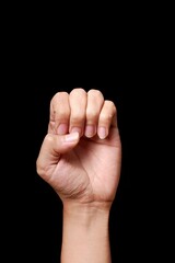 Hand making a fist on black background.