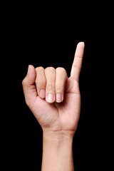 Hand with index finger pointing up on black background.