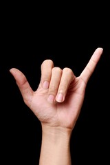 Hand showing a shaka sign on black background.