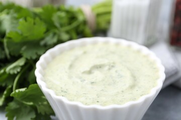 Tasty cilantro sauce in bowl on grey table, closeup