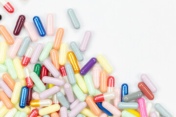 Colorful medicine pills and capsules forming a border frame with copy space. A pharmaceutical and healthcare concept for backgrounds and design. isolated on white background with clipping path.