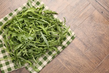 Fresh ripe green arugula leaves on wooden table, top view. Space for text