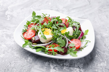 Tasty salad with arugula, vegetables, egg and seeds on grey table, closeup