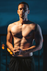 Muscular athlete posing powerfully at night, strength and dedication, Toned man with perfect body displaying power and discipline in evening silhouette