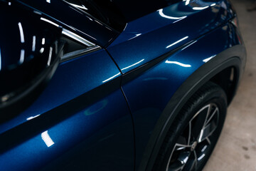Close-up of blue SUV fender and door with glossy ceramic coating – perfect reflections and clean panel alignment under LED lighting for car detailing, PPF application and automotive promo content