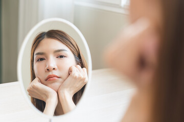 Anti aging, worry puberty asian young woman, stressed girl looking in mirror, allergy presenting an...