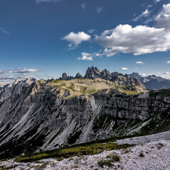 Wide view of Cadini di Misurina peaks rising above layered limestone cliffs and alpine trails in the Italian Dolomites