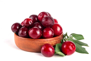Fresh raw ripe cherry plum with leaves. Bowl of tasty farm bright red cherry plum fruits, in wooden craft bowl on white wooden background copy space