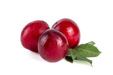 Fresh raw ripe cherry plum with leaves. Bowl of tasty farm bright red cherry plum fruits, in wooden craft bowl on white wooden background copy space