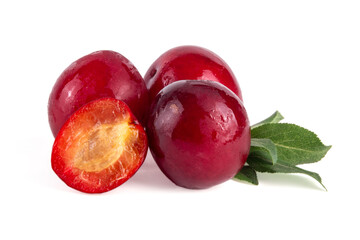 Fresh raw ripe cherry plum with leaves. Bowl of tasty farm bright red cherry plum fruits, in wooden craft bowl on white wooden background copy space