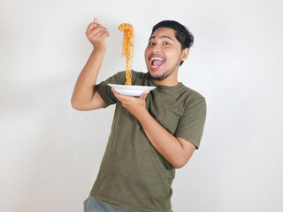 happy Handsome Asian man enjoying fried noodles with a fork. Eating lunch concept. Isolated white background