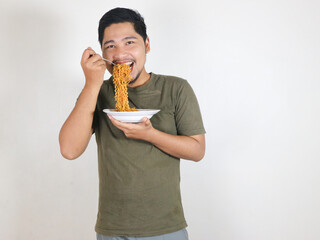 Handsome Asian man enjoying noodles with a fork. Eating lunch concept. Isolated white background