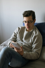 Man sitting in bed looking at cell phone