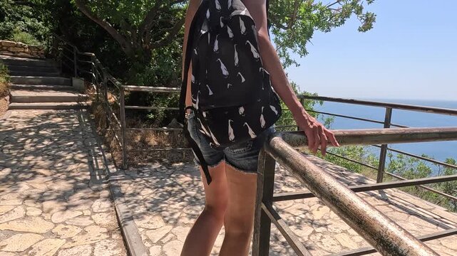 Woman backpack hiking, enjoying ocean view from mountain top. Freedom and travel concept.