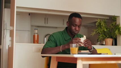 Man Eating a Sandwich and Drinking Juice - Powered by Adobe