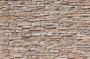 Stone coating wall made of striped stacked bricks of natural brown rocks. Panels for exterior. Background and texture.